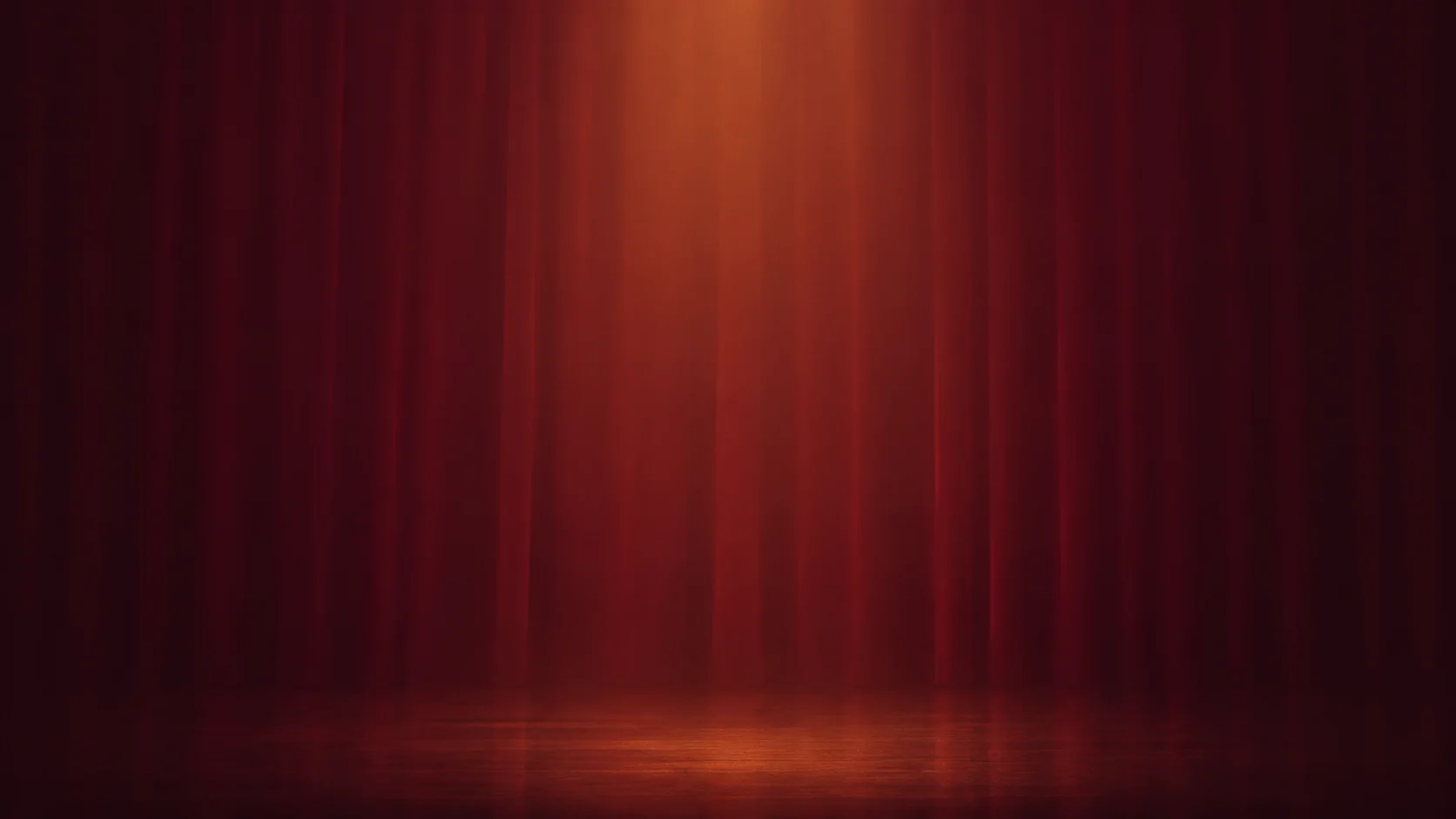 A warm burgundy curtain washed in final-stage lighting
