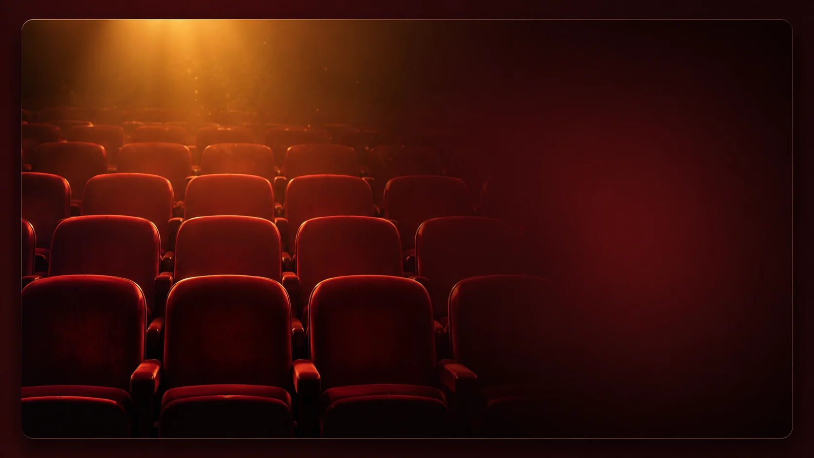 Rows of burgundy theater seats glowing under warm auditorium lighting